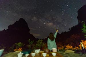 a woman pointing to the stars in the night sky at Yangshuo Yunshe Mountain Guesthouse in Yangshuo