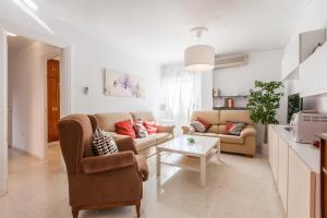 ein Wohnzimmer mit 2 Sofas und einem Tisch in der Unterkunft TRIANA WITH FREE PARKING in Sevilla