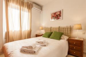 ein Schlafzimmer mit einem Bett mit Handtüchern darauf in der Unterkunft TRIANA WITH FREE PARKING in Sevilla
