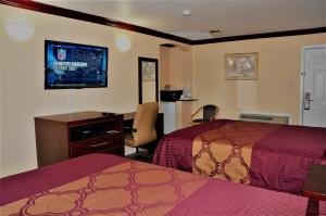 メアリーズビルにあるAmericas Deluxe Inn- Marysvilleのベッド2台とデスクが備わるホテルルームです。