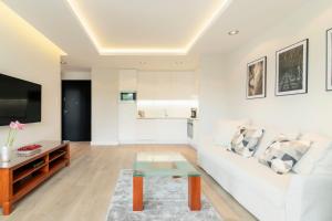 a living room with a white couch and a table at Luxury Apartments - Okrzei Residence by Grand Apartments in Sopot