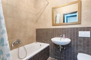 a bathroom with a sink and a tub and a mirror at Apartment Dagmar in Peroj
