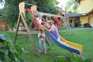 a group of children playing on a slide at a playground at Ferienwohnungen Simonbauer in Trebesing