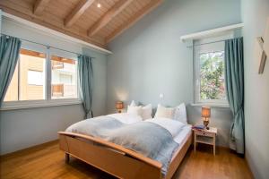 1 dormitorio con 1 cama y 2 ventanas en Chalet Sunshine, en Saas-Fee