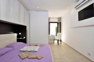 a bedroom with a purple bed and a tv at B&B La Torre in Loceri