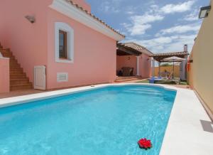 eine Villa mit Swimmingpool und ein Haus in der Unterkunft Villa Bella Lucia 1. Piscina Climatizada, WiFi, BBQ. in Corralejo