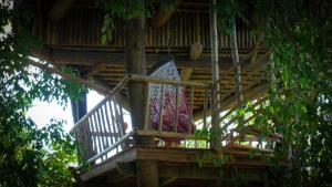 パランカラヤにあるBukit Raya Guesthouseの敷物が敷かれた木造家屋のバルコニー