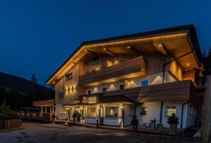 a large building with a wooden facade at night at Die Waldruhe in Kartitsch