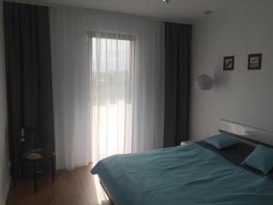1 dormitorio con cama y ventana grande en Baltic Apartament z basenem zewnętrznym ul Marynarska 4, Sarbinowo, en Sarbinowo