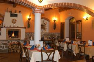 a restaurant with tables and chairs and a fireplace at Penzion Planicka in Černá v Pošumaví