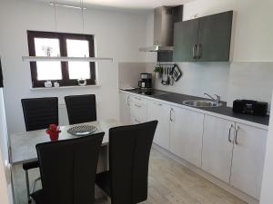 a kitchen with a table and chairs and a sink at Ferienwohnung Auszeit Bad Belzig Näthe in Bad Belzig