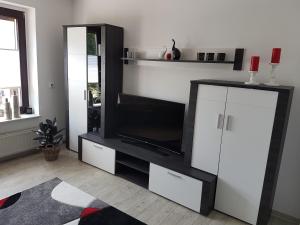 a living room with a entertainment center with a television at Ferienwohnung Auszeit Bad Belzig Näthe in Bad Belzig