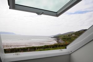 a window in a house with a view of the beach at Seascapes in Inch