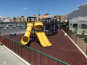 un parque infantil con tobogán amarillo en Bungalow Einstein en Maspalomas