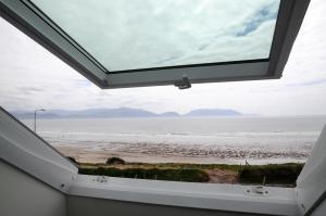 Blick auf den Strand vom Fenster eines Hauses in der Unterkunft Seascapes in Inch