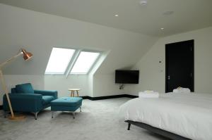 a bedroom with a bed and a chair and a tv at Seascapes in Inch