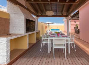 eine Terrasse mit Tisch und Stühlen auf einem Deck in der Unterkunft Villa Bella Lucia 1. Piscina Climatizada, WiFi, BBQ. in Corralejo