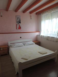 a bedroom with a white bed with a window at Apartman Sole in Bale