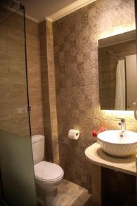 a bathroom with a toilet and a sink and a mirror at Bellarias House in Nydri