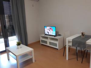 sala de estar con TV y mesa en Apartamentos Begastri en Cehegín