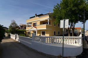 a yellow house with a white fence in front of it at Villa Sophie in Betina