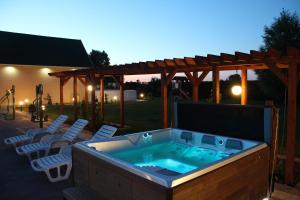 a hot tub in a deck with chairs and a pergola at Verano in Osieki