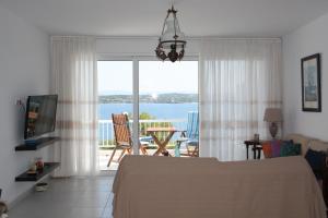 iliana's seaside maisonette في سبيتسيس: غرفة نوم مع سرير وإطلالة على المحيط