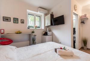 een slaapkamer met een bed en een tv aan de muur bij Guest House Beach & City in Split