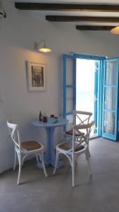 a table and chairs in a room with a window at Aegean Eye Apartments in Kastron