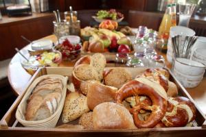 a tray of different types of bread and pretzels on a table at Adler Oberdorf in Langenargen