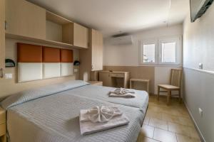 ein Schlafzimmer mit einem Bett mit zwei Handtüchern darauf in der Unterkunft Hotel Stresa in Rimini