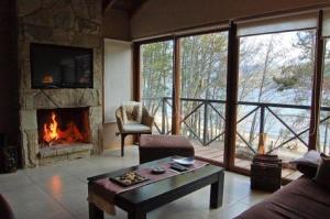 een woonkamer met een open haard en een bank bij Orillas del Gutierrez in Bariloche