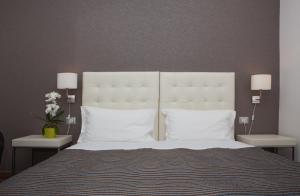 1 dormitorio con 1 cama grande con almohadas blancas en B&B Night&Day, en Reggio Calabria