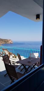 una mesa y sillas en un balcón con vistas al océano en Aegean Eye Apartments, en Kástron