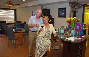 an older man standing next to a woman holding a glass of wine at Cheers B&B in West Kelowna
