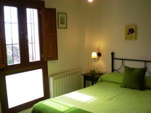 1 dormitorio con 2 camas verdes y ventana en Apartamentos San Martin, en Cuenca