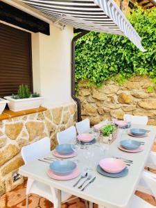 a white table with plates and napkins on it at Casa Rural Cabeza Lobera in Villanueva de Ávila