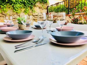 a table with bowls and plates and wine glasses on it at Casa Rural Cabeza Lobera in Villanueva de Ávila