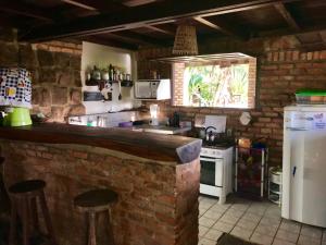 Una cocina con encimera y pared de ladrillo. en Hostel do Ceu, en Pipa