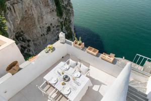 a table and chairs on a balcony next to the water at Gli Orti Di Malva B&B in Peschici