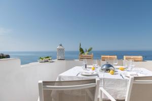 uma mesa de jantar branca com vista para o oceano em Gli Orti Di Malva B&B em Peschici