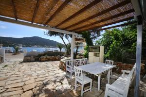 a table and chairs on a patio with a view of the water at Sound System in Vinišće