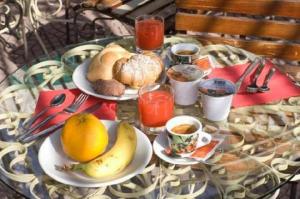 a glass table topped with plates of food and fruit at Hotel Vela Velo Club Vieste in Vieste
