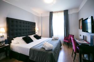a hotel room with a large bed and a television at La Casa de la Trinidad in Granada