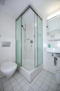 a bathroom with a shower and a toilet and a sink at Akademie der Dioezese in Stuttgart