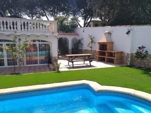 une arrière-cour avec une piscine et une table de pique-nique dans l'établissement Alojamiento BOGUES, à Lloret de Mar