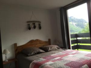 um quarto com uma cama e uma grande janela em Les Esserts em Les Houches