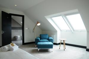a bedroom with a blue chair and a bed at Seascapes in Inch