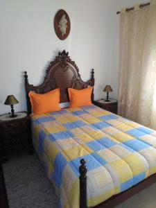 ナザレにあるMoradia Salesのベッドルーム1室(青と黄色のキルトのベッド1台付)