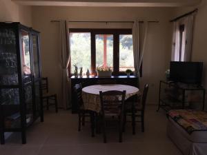 a dining room with a table and chairs and a window at Athinaios Porto Klisouri Villa in Ierissos